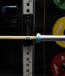 Barbell with weight plates on a weight rack, featuring 'Origin' band branding.