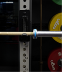 Barbell with weight plates on a weight rack, featuring 'Origin' band branding.