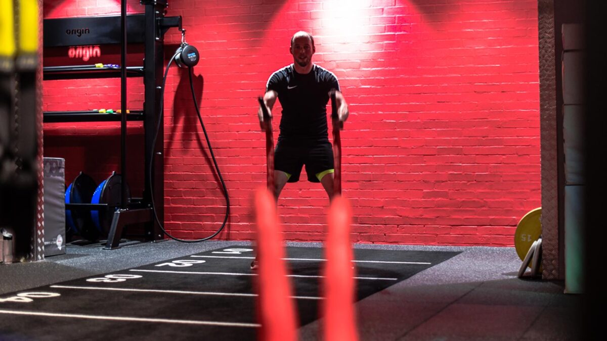 man slamming battleropes in sports club 