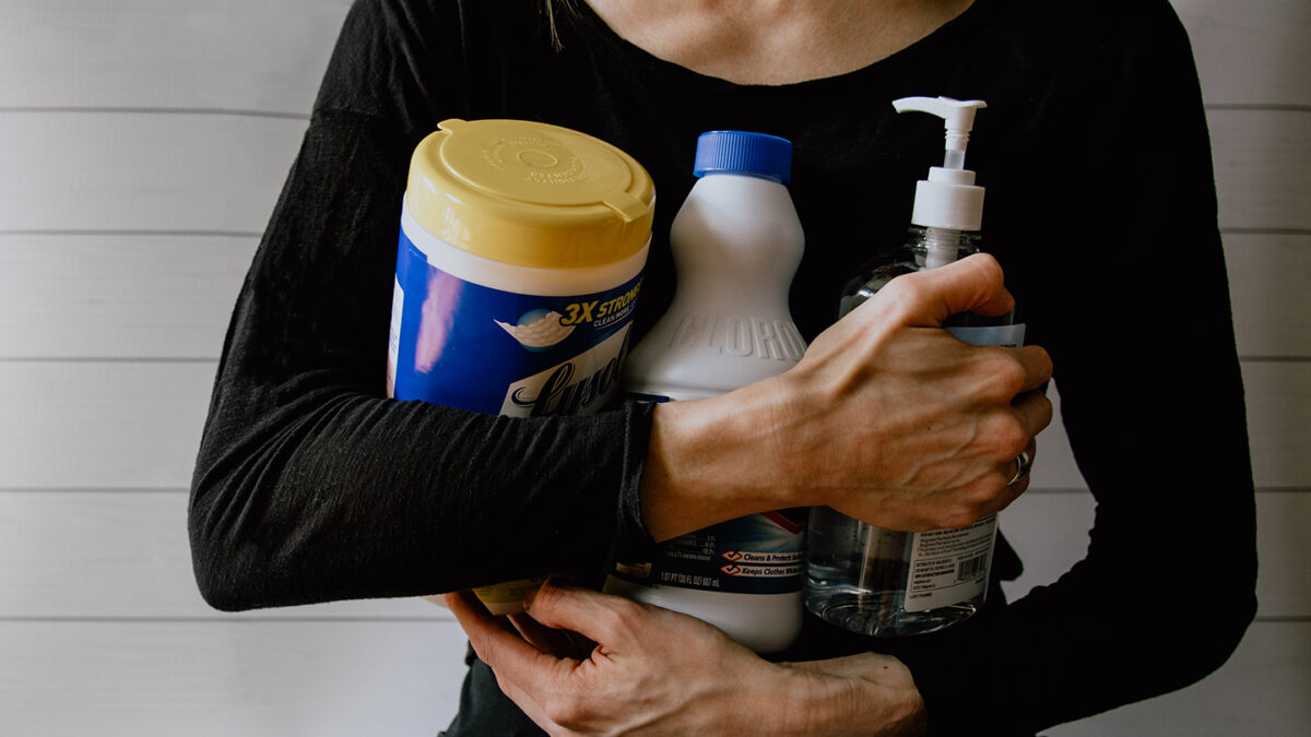 Person clutching cleaning products