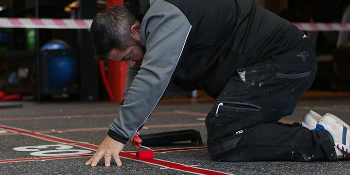 Origin Fitness engineer installing gym flooring 