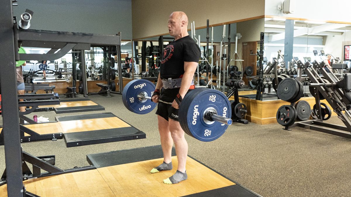 man lifting weight plates in weight